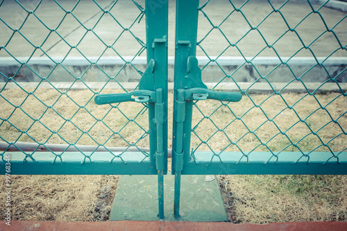 Green metal fence lock with pastel tone