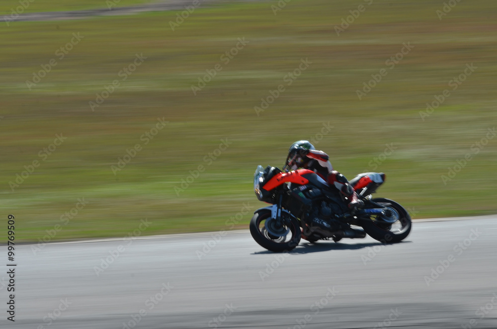 Blurred athletes practicing racing motorcycles on the race track