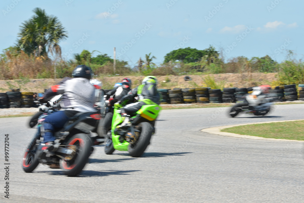 Fototapeta premium Niewyraźni sportowcy uprawiający motocykle wyścigowe na torze wyścigowym