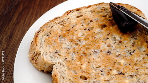 Spreading Australian Vegemite on whole wheat toast in slow motion photo