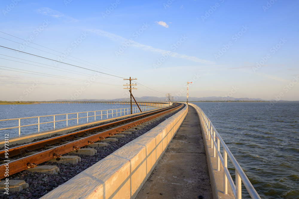 railway or railroad crossing to the lake with the morning light