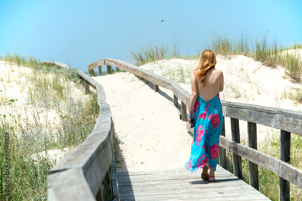 Girl is walking in the vast sand dunes of the Uruguayan coast