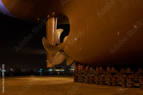 Night view of the ship's stern and screw standing on a dock in Gdansk Repair Shipyard