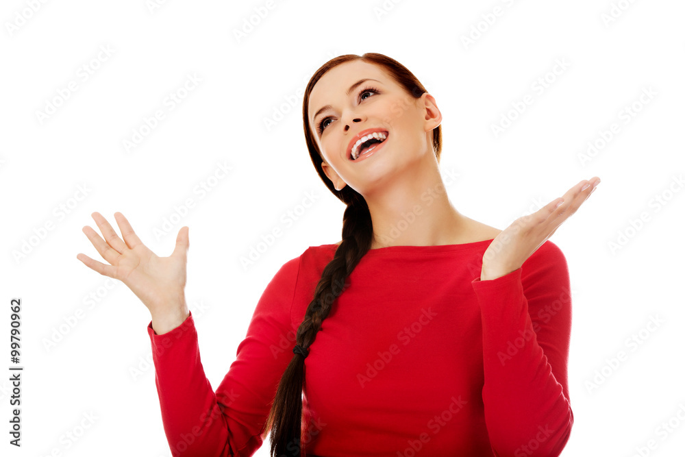 Happy young woman trying to catch something falling from the sky Happy young woman trying to catch something falling from the sky