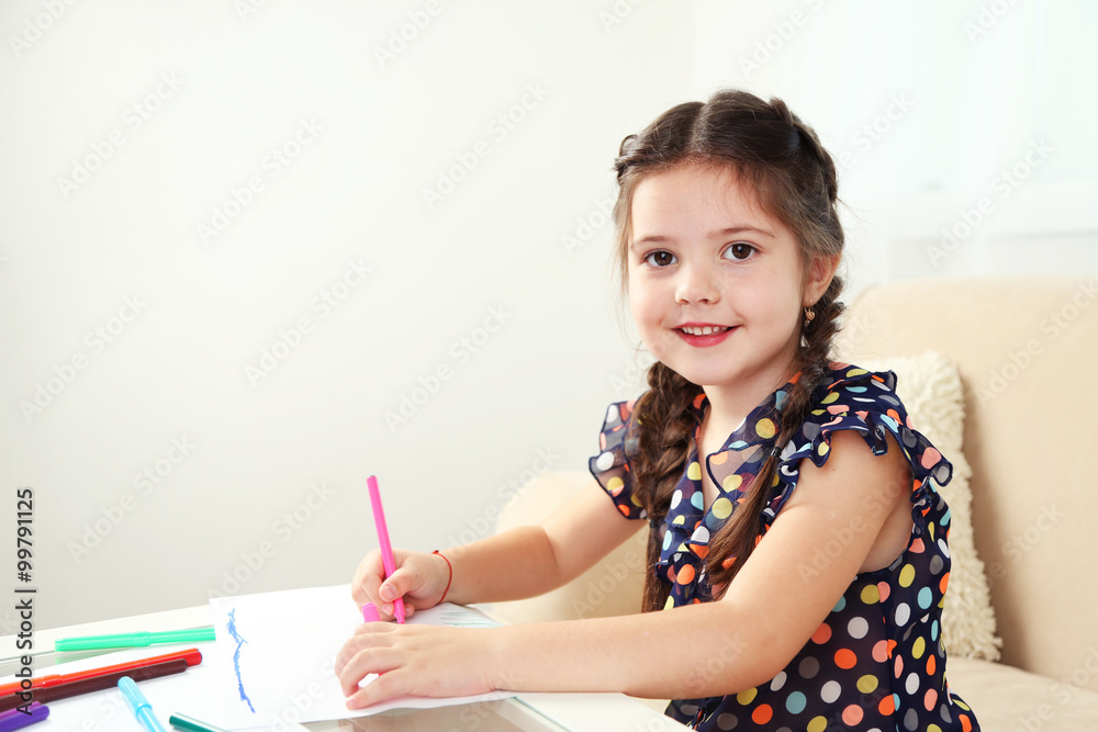 Cute little girl drawing picture on home interior background Cute little girl drawing picture on home interior background