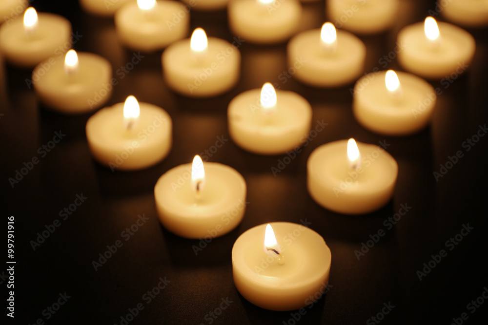 Alight candles in a row on black background Alight candles in a row on black background