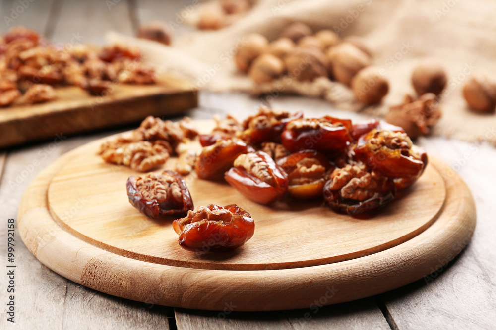 Walnut, date fruit on wooden table, close-up Walnut, date fruit on wooden table, close-up
