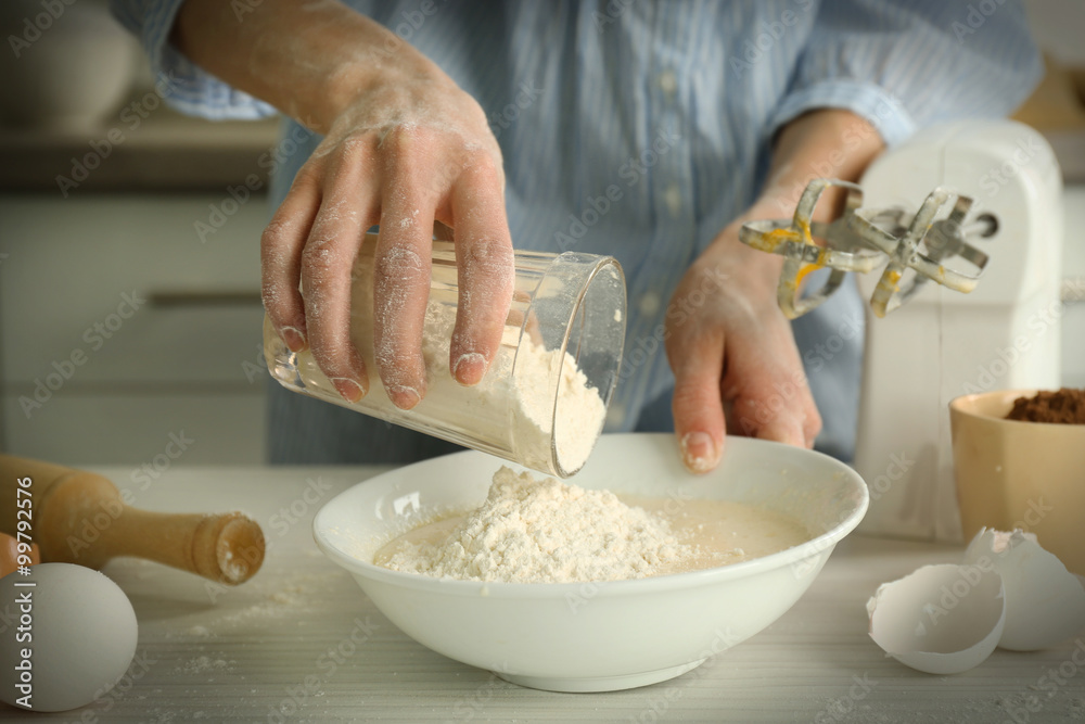 Woman is adding flour to the mixture Woman is adding flour to the mixture