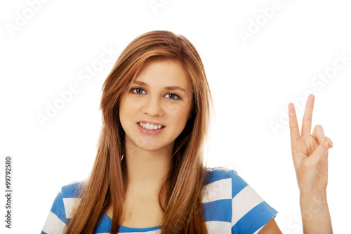 Teenage woman showing victory sign