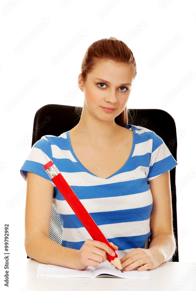 Teenage woman doing notes with a huge pen Teenage woman doing notes with a huge pen