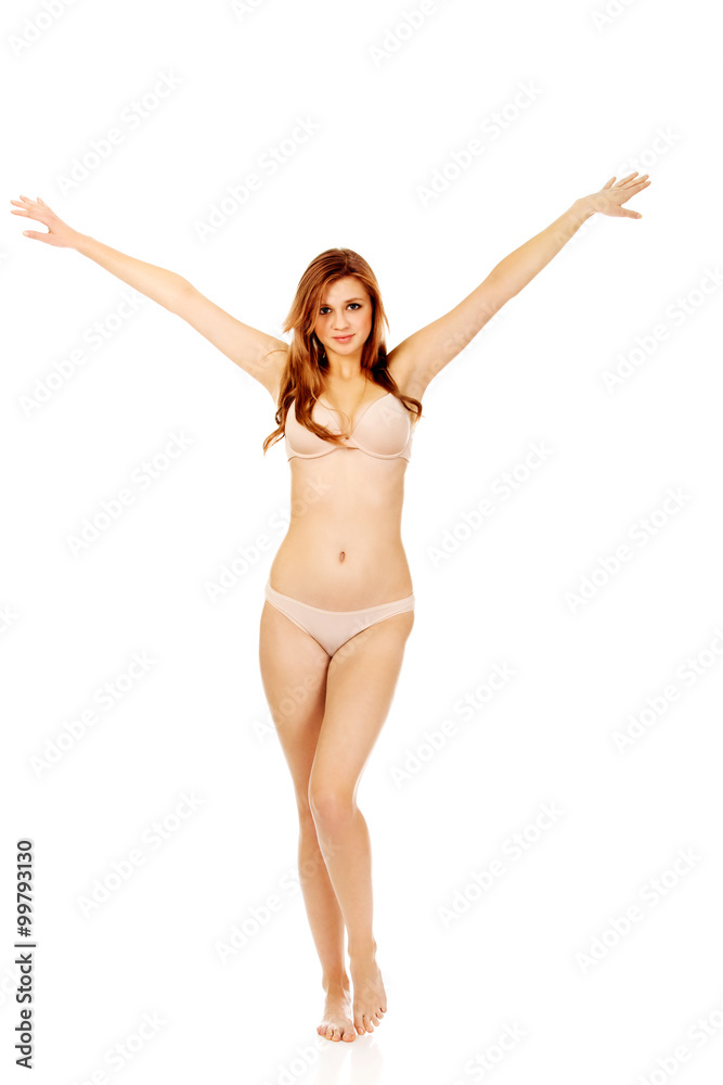 Happy young woman in beige underwear with arms up Happy young woman in beige underwear with arms up