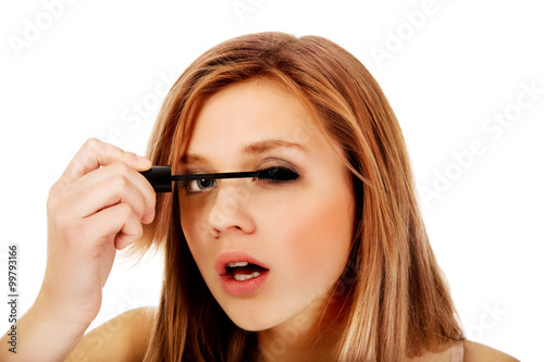 Teenage beautiful woman applying mascara