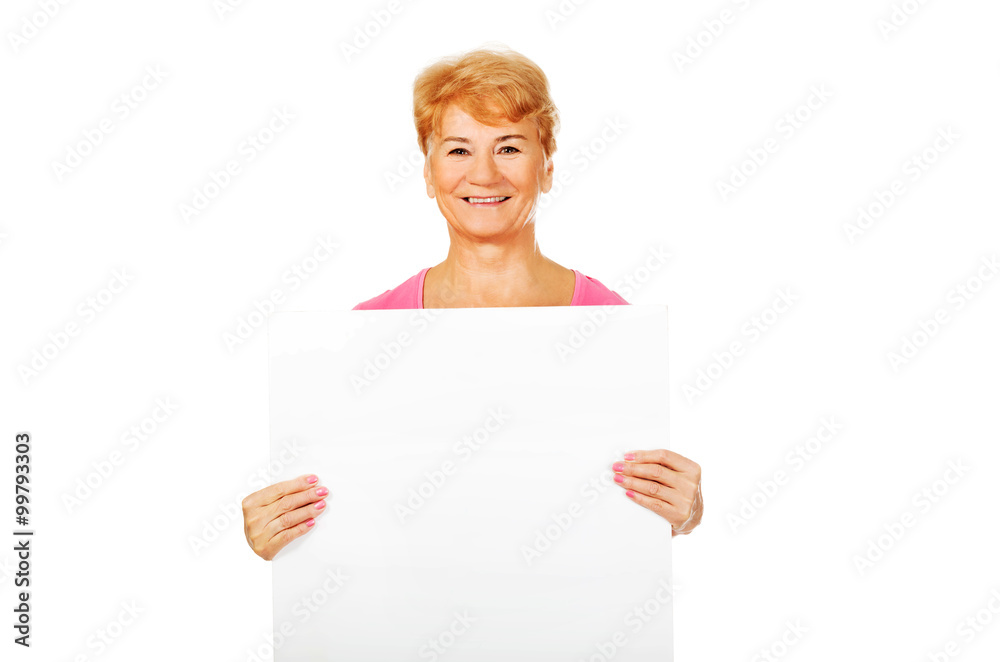 Smiling senior woman holding empty banner