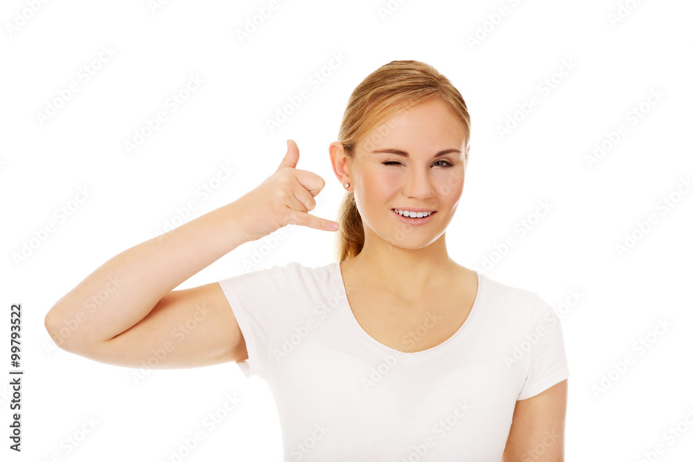 Young woman gesturing call me sign Young woman gesturing call me sign