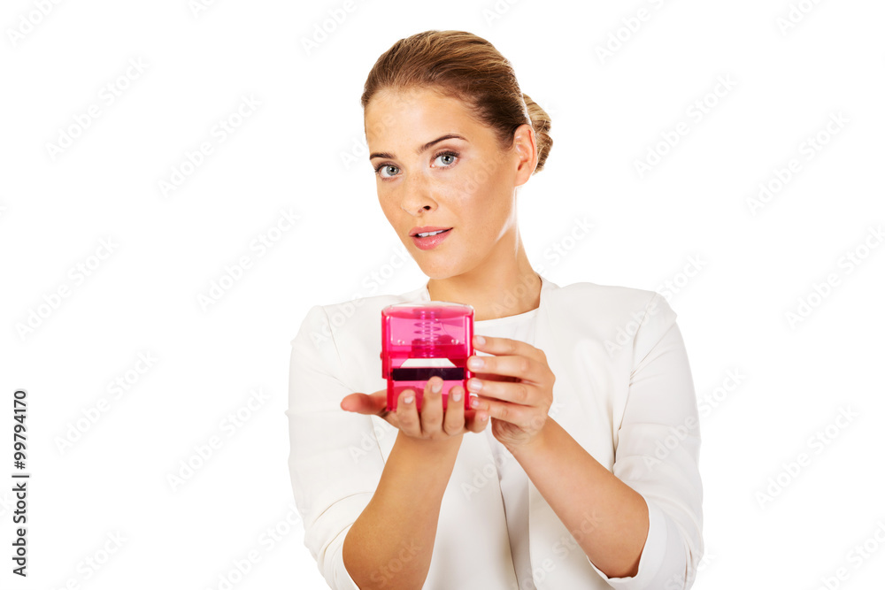 Young businesswoman holding pink rubber stamp Young businesswoman holding pink rubber stamp