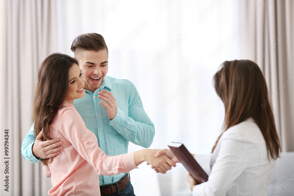 Woman shaking hands with estate agent in new home Woman shaking hands with estate agent in new home