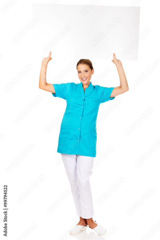 Young female doctor or nurse holding empty banner