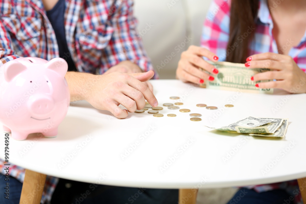 Fototapeta premium Happy couple counting money from the moneybox