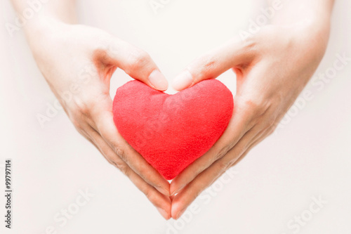 Female hand holding a red heart