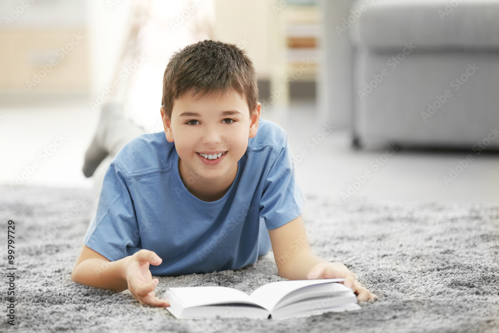 Boy with book lying on a floor at home Boy with book lying on a floor at home