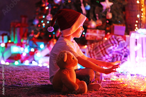 Little boy in Santa hat sit...