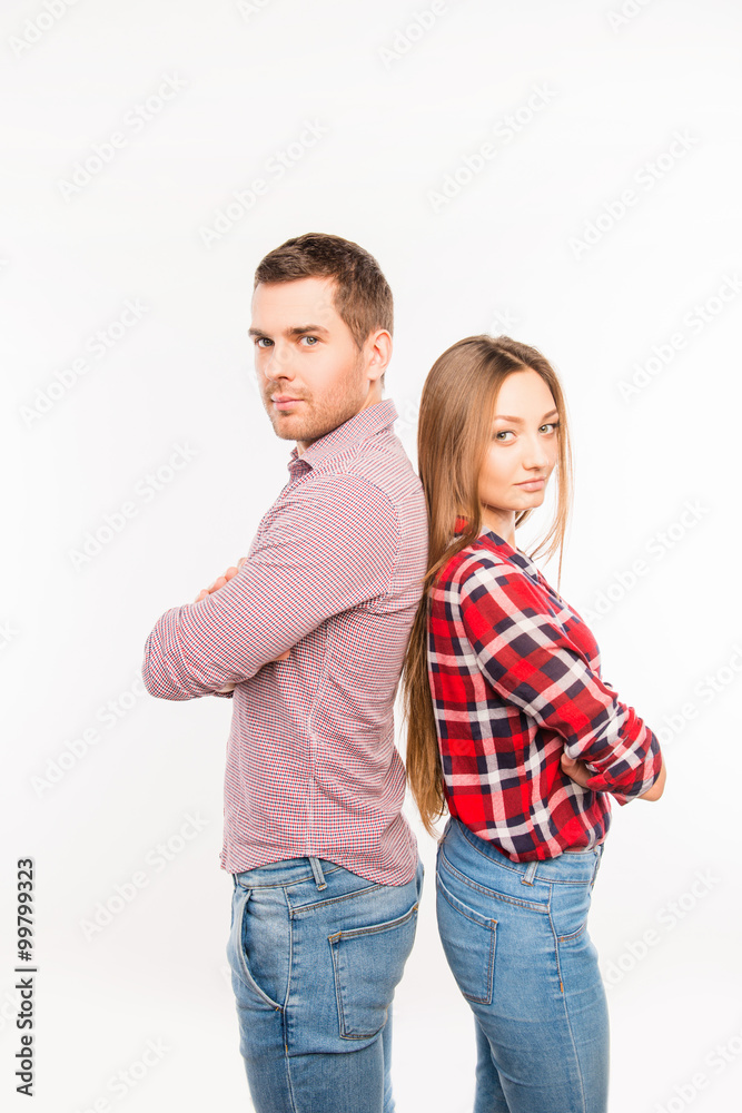 Couple in love standing back to back with crossed hands Couple in love standing back to back with crossed hands