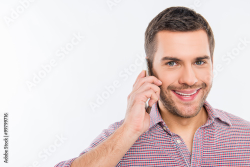 Close up photo of handsome happy man talking on the phone
