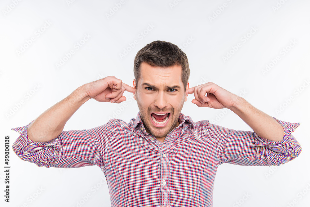 Attractive man clossing his ears and screaming Attractive man clossing his ears and screaming