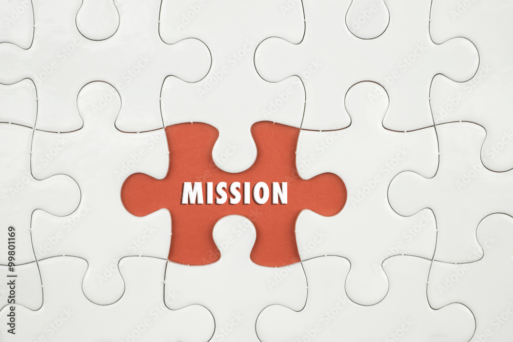 Jigsaw puzzle on color paper background with a word MISSION Jigsaw puzzle on color paper background with a word MISSION