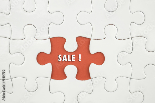 Jigsaw puzzle on color paper background with a word SALE!