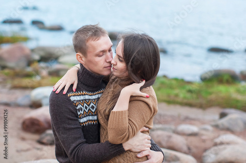 Loving couple hugging on the rocky beach