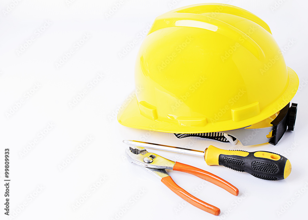 Helmet with screwdriver and pliers on white backgrounds Helmet with screwdriver and pliers on white backgrounds