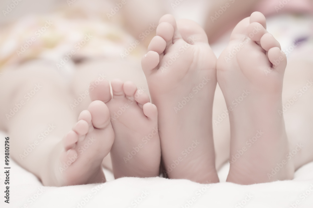 Two pairs of children's legs on the bed. The concept of a happy family.