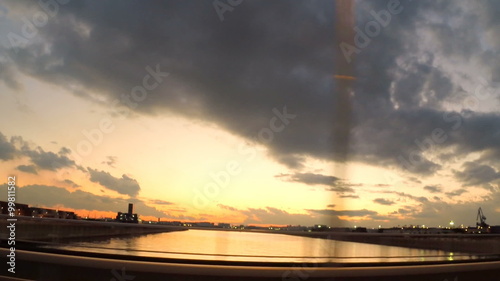 Side view of sunset skies from a running car.