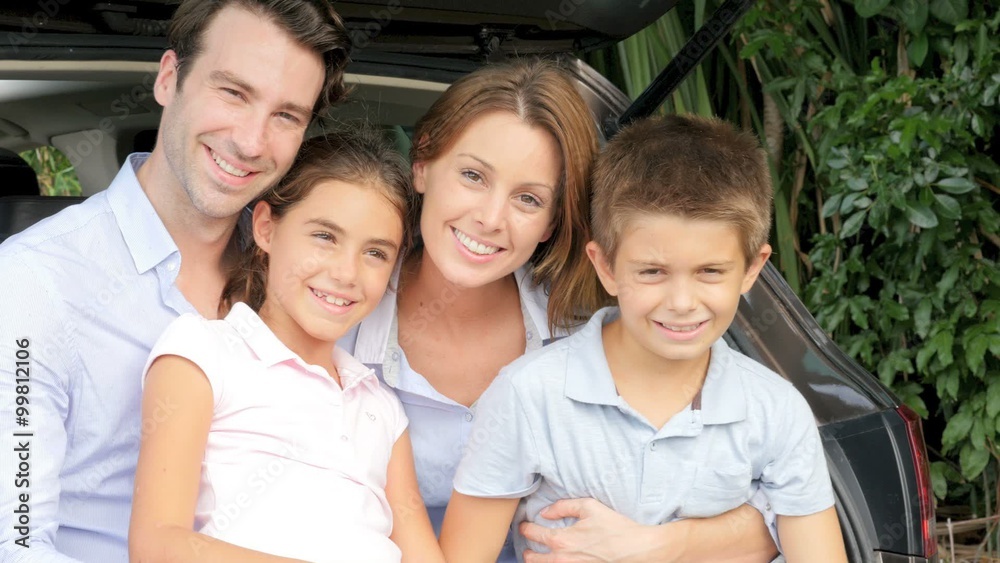 Family sitting in car trunk, ready for vacation Family sitting in car trunk, ready for vacation