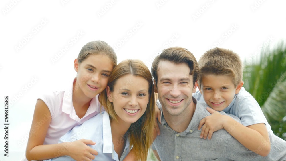 Parents giving piggyback ride to kids outside Parents giving piggyback ride to kids outside