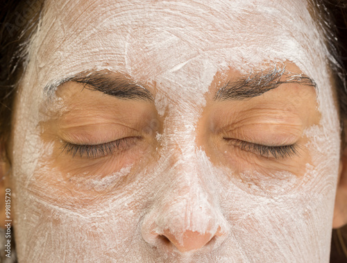 Woman closed eyes and forehead with mudpack and nose, front view photo