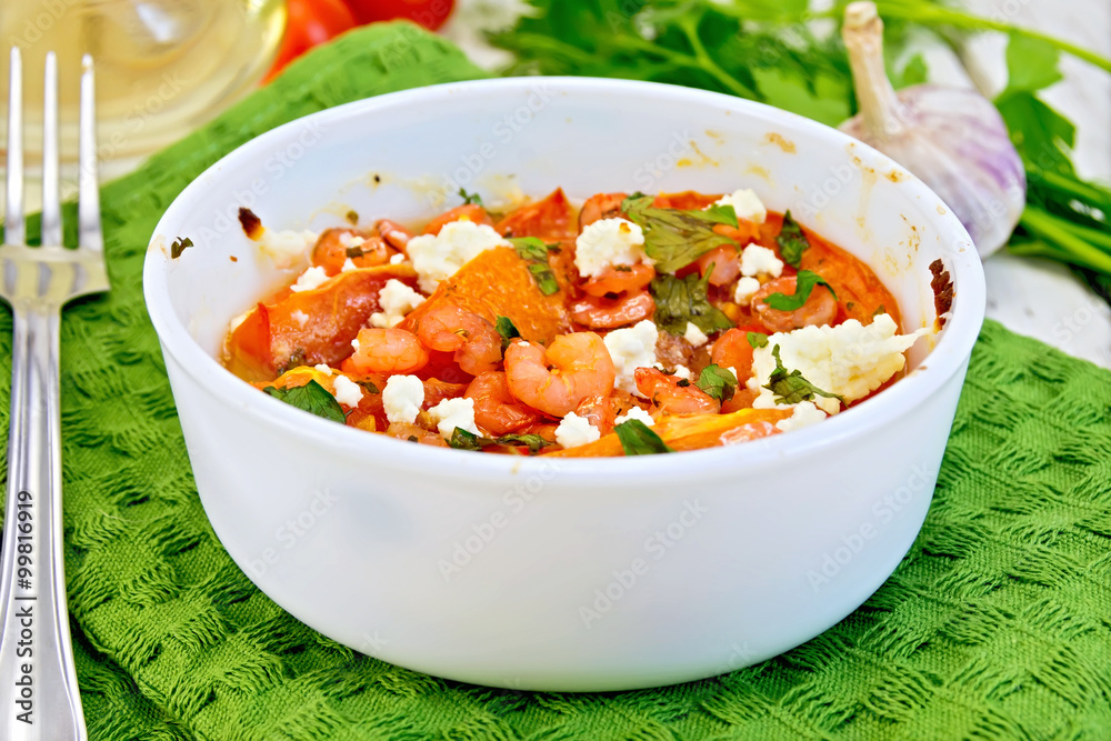 Shrimp and tomatoes with feta in white bowl on board Shrimp and tomatoes with feta in white bowl on board