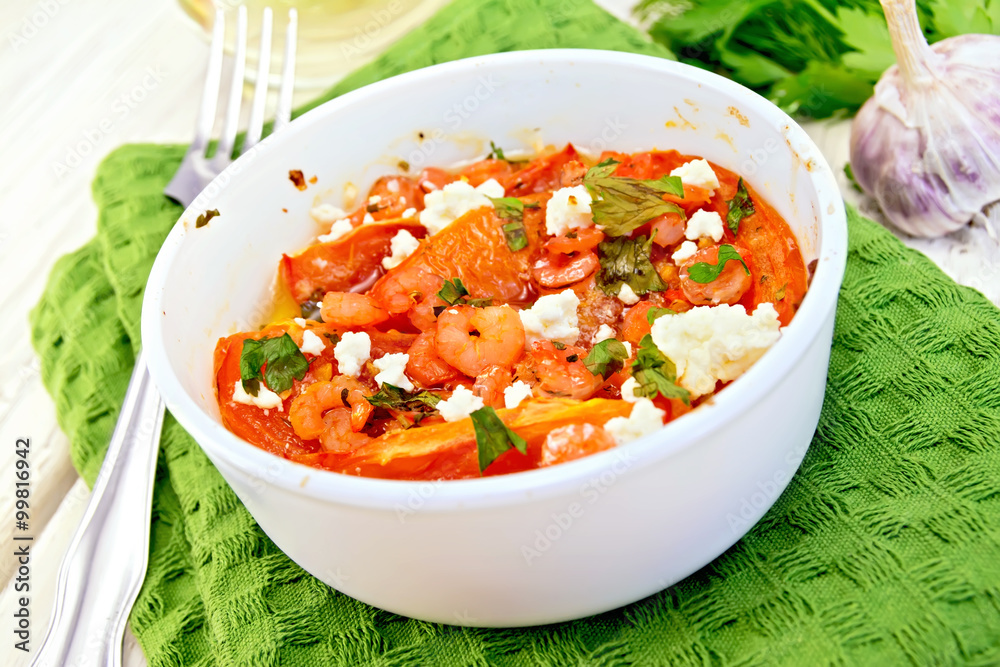 Shrimp and tomatoes with feta in white bowl on light board Shrimp and tomatoes with feta in white bowl on light board