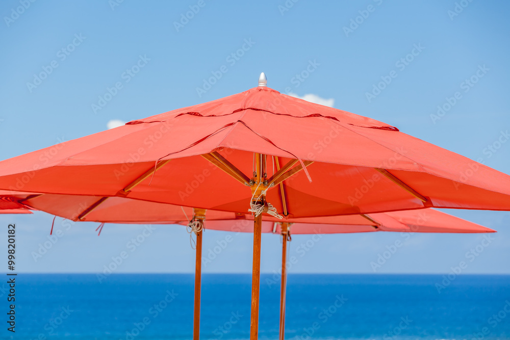parasols rouges sur fond bleu 