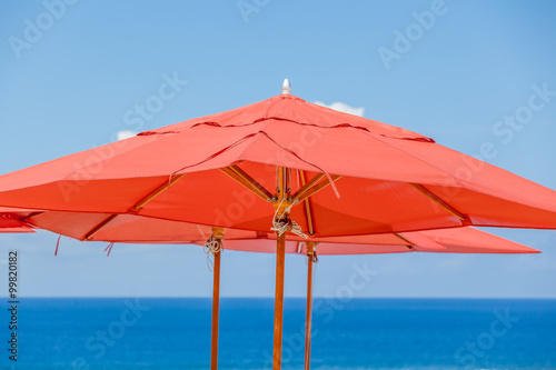 parasols rouges sur fond bleu  © Unclesam
