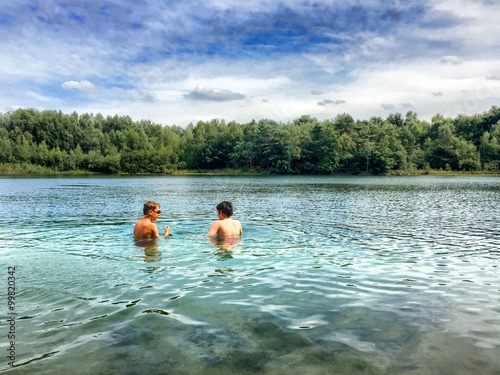 two teenage bouq swimming in the lake photo