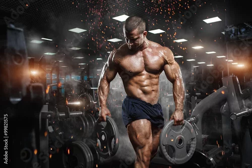 Obraz Mięśni lekkoatletycznego kulturysta model fitness pozowanie po ćwiczeniach w siłowni