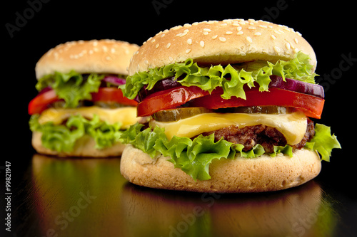 Big two cheeseburgers isolated on black background