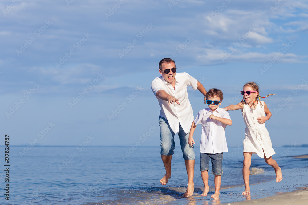 Father and children playing on the beach at the day time. Father and children playing on the beach at the day time.