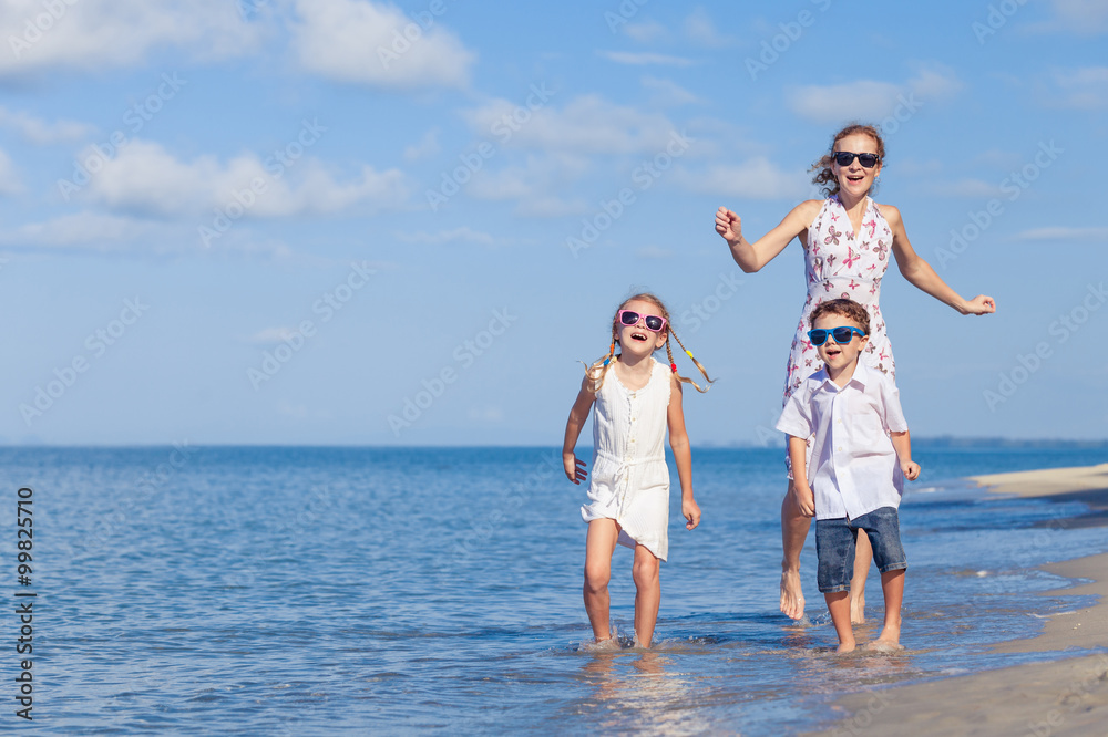 Mother and children playing on the beach at the day time. Mother and children playing on the beach at the day time.