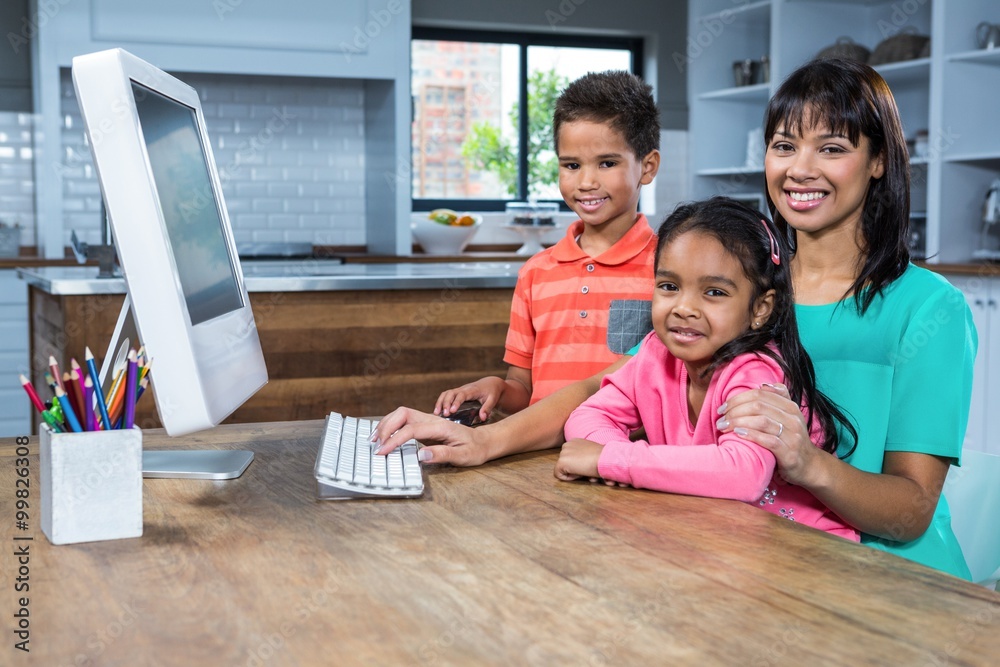 Happy mother using computer with her children Happy mother using computer with her children