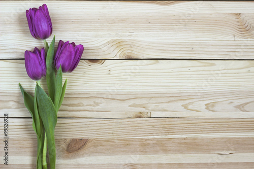 Fototapeta Naklejka Na Ścianę i Meble -  Lilac tulips on wooden background from above, holiday design with free text space