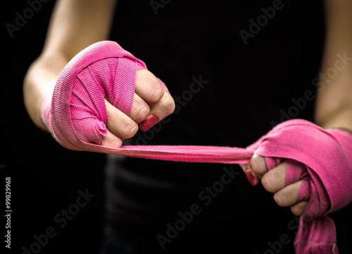 Woman is wrapping hands with pink boxing wraps