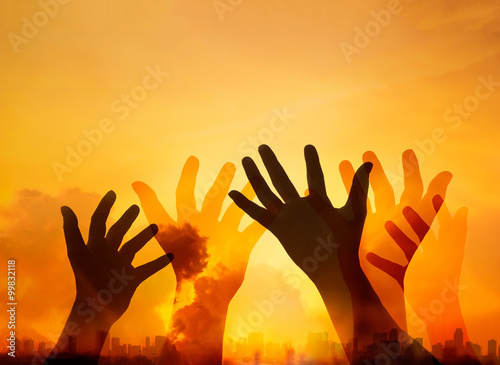 Human hands while respecting and praying on the sunset in city background
